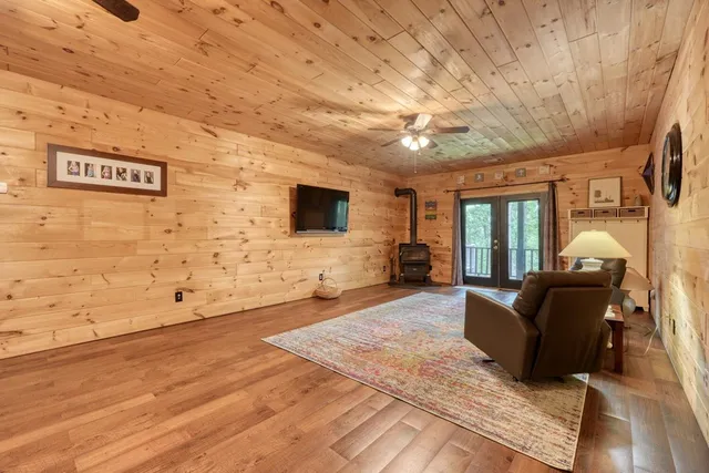 a living room with couches bookshelf and a flat screen tv