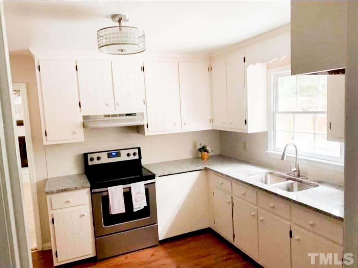 5601 Russell Road Durham, NC 27712 - Photo 7 of 10 a kitchen with stainless steel appliances a sink stove and cabinets