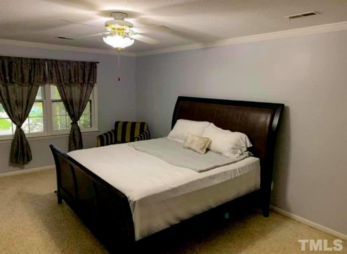 5601 Russell Road Durham, NC 27712 - Photo 8 of 10 a bed sitting in a bedroom next to a window