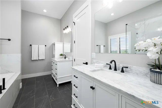 a bathroom with double vanity sink a mirror and shower