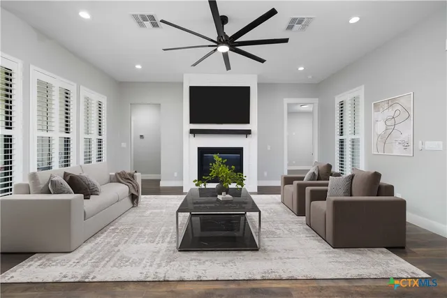 a living room with furniture a flat screen tv and a fireplace