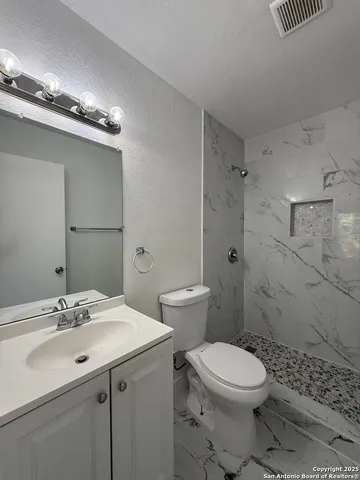 a bathroom with a sink toilet and shower
