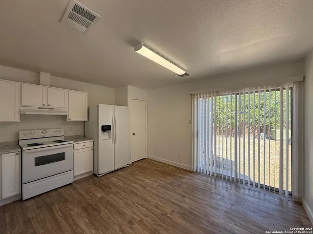 a kitchen with granite countertop a stove and a refrigerator
