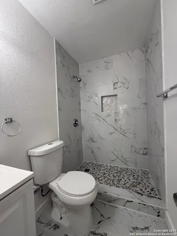a bathroom with a toilet and a shower