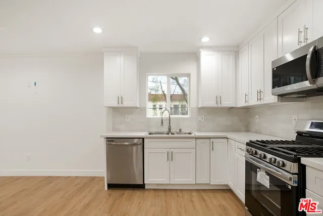 a kitchen with stainless steel appliances a sink a stove and microwave