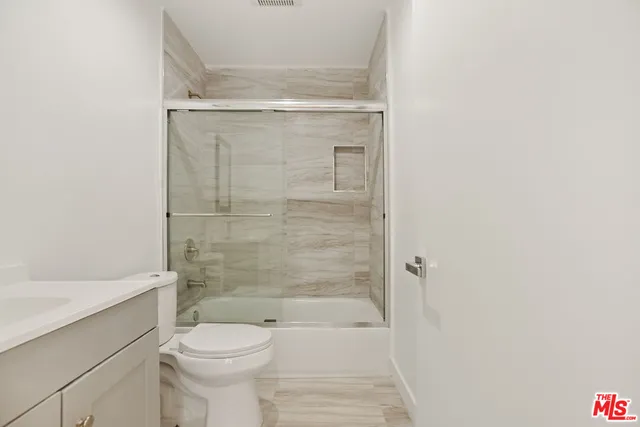 a bathroom with a shower a toilet and a sink