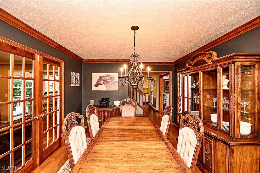 1236 Spring Valley Avenue Northwest Canton, OH 44708 - Photo 6 of 28 Dining room with french doors, a chandelier, wood finished floors, and a textured ceiling
