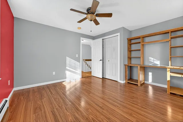 a view of a big room with wooden floor and windows