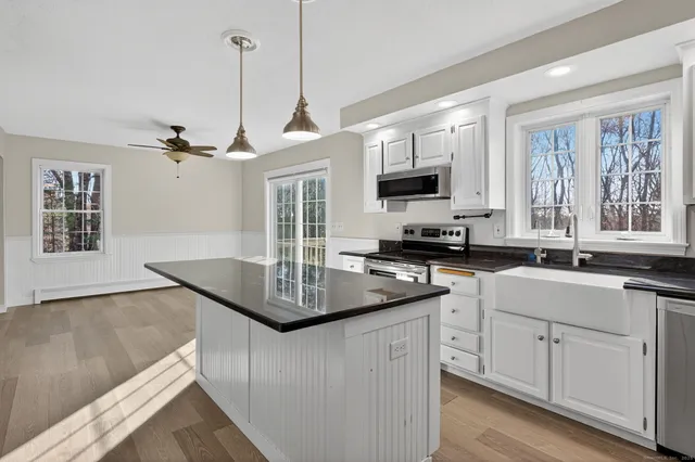 a kitchen with stainless steel appliances granite countertop a sink a stove and a microwave