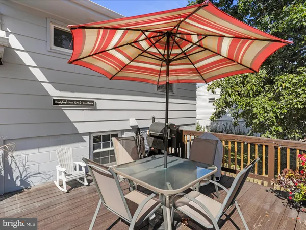 a roof deck with a dining table and chairs under an umbrella