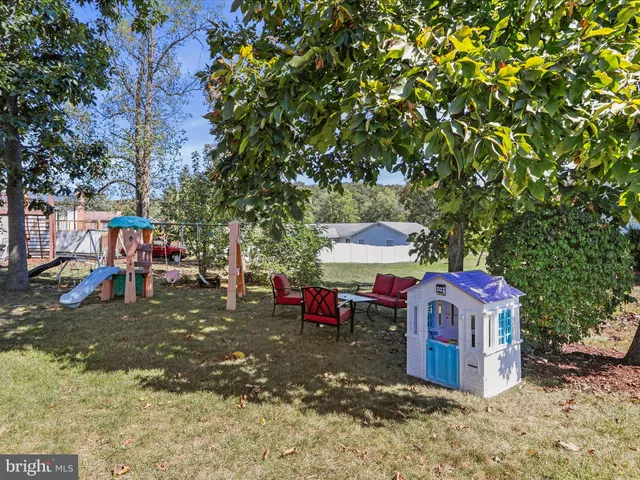 a view of a patio with table and chairs potted plants and a large tree