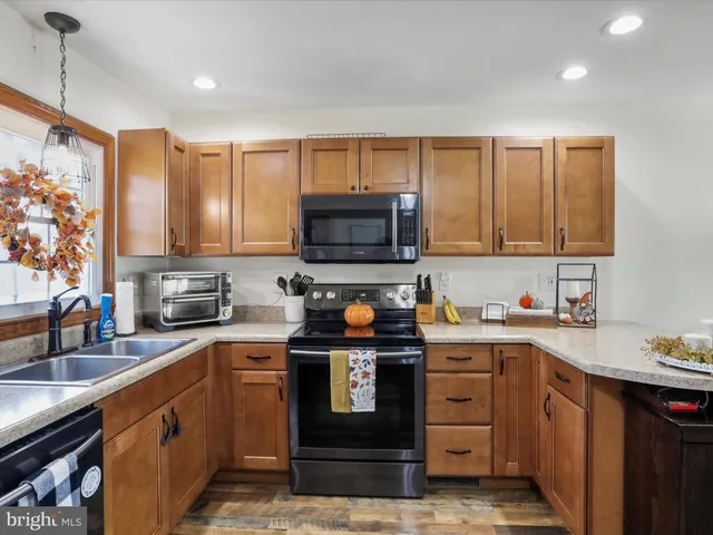 a kitchen with stainless steel appliances granite countertop a stove a sink and a microwave