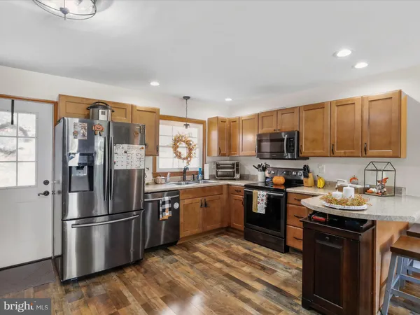 a kitchen with stainless steel appliances granite countertop a refrigerator stove microwave and sink