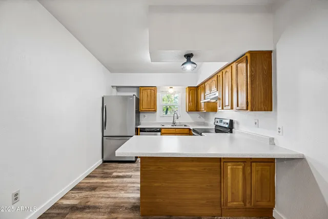 a kitchen with stainless steel appliances a refrigerator sink and microwave