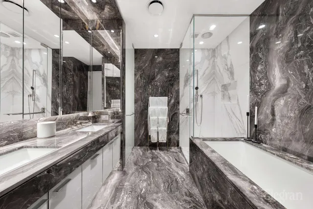 a bathroom with a granite countertop double vanity sink a mirror and shower