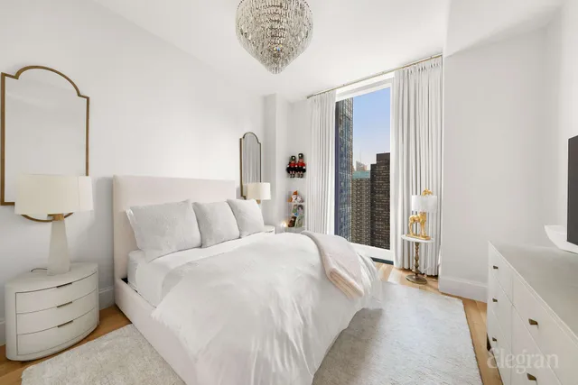 a bedroom with a bed and a chandelier