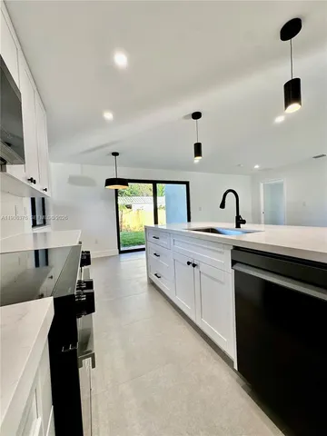a large kitchen with stainless steel appliances a large counter top
