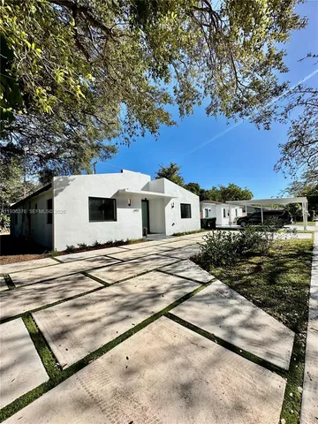 a view of a white house with a yard