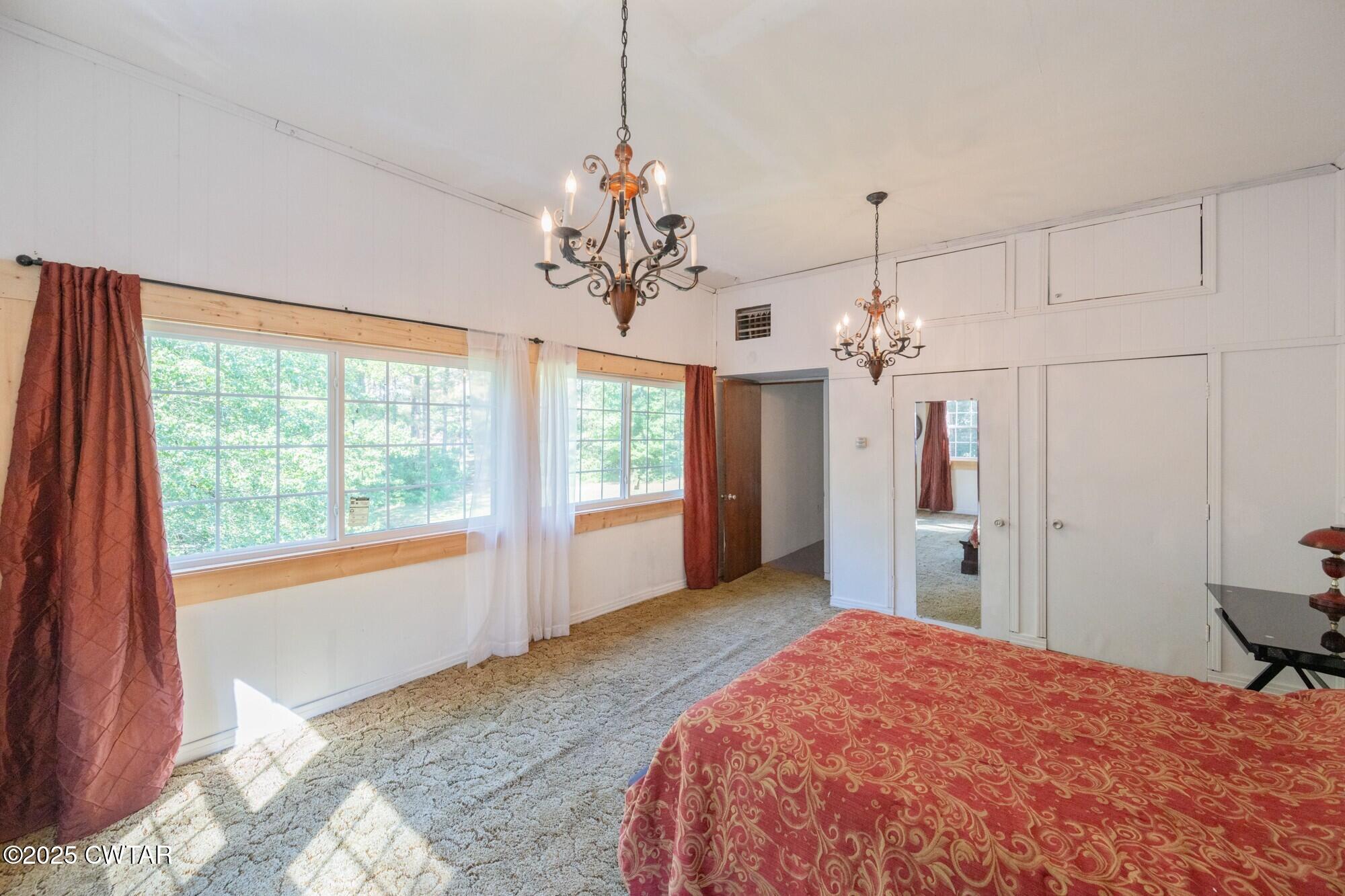 1035 Beacon Road Parsons, TN 38363 - Photo 41 of 70 a spacious bedroom with a bed and a chandelier