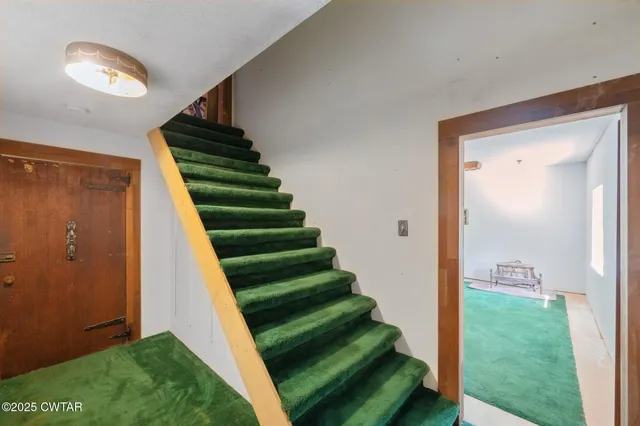 an aerial view of residential house with outdoor space and trees all around