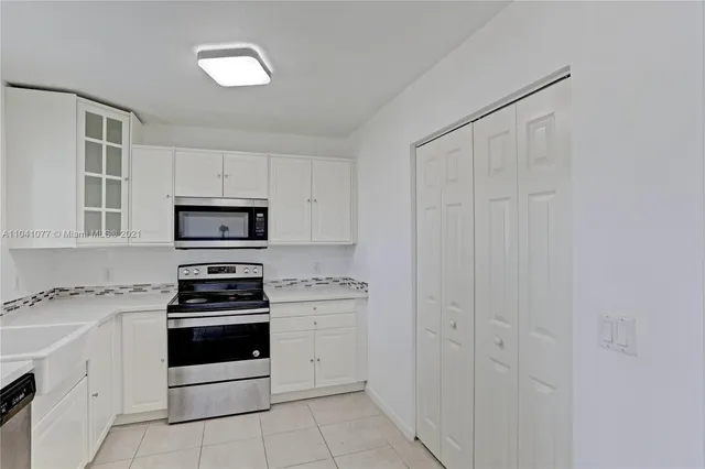 a kitchen with white cabinets and white appliances