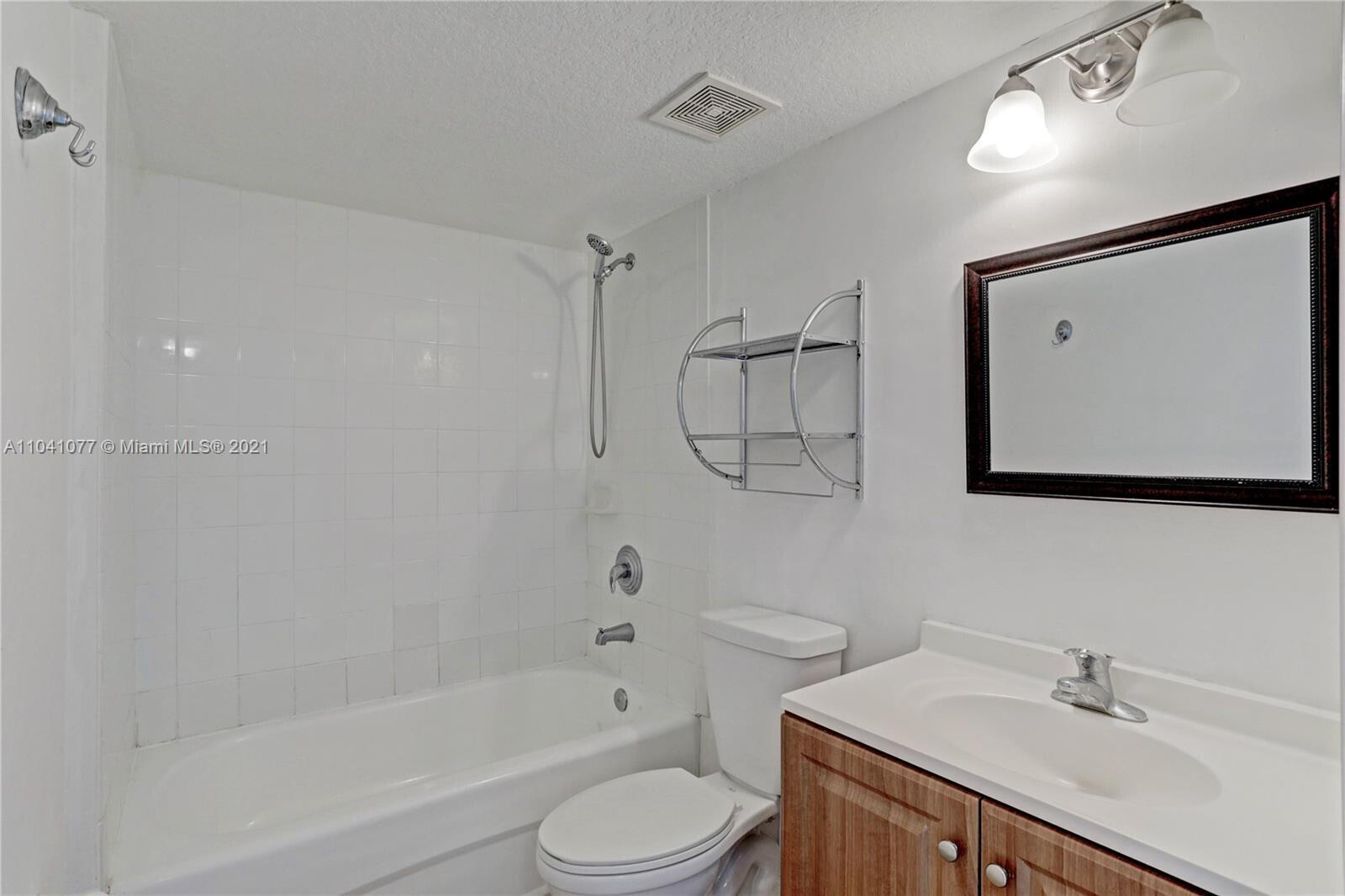 3810 North Jog Road, Unit 106 West Palm Beach, FL 33411 - Photo 10 of 13 a bathroom with a bathtub shower sink vanity and toilet