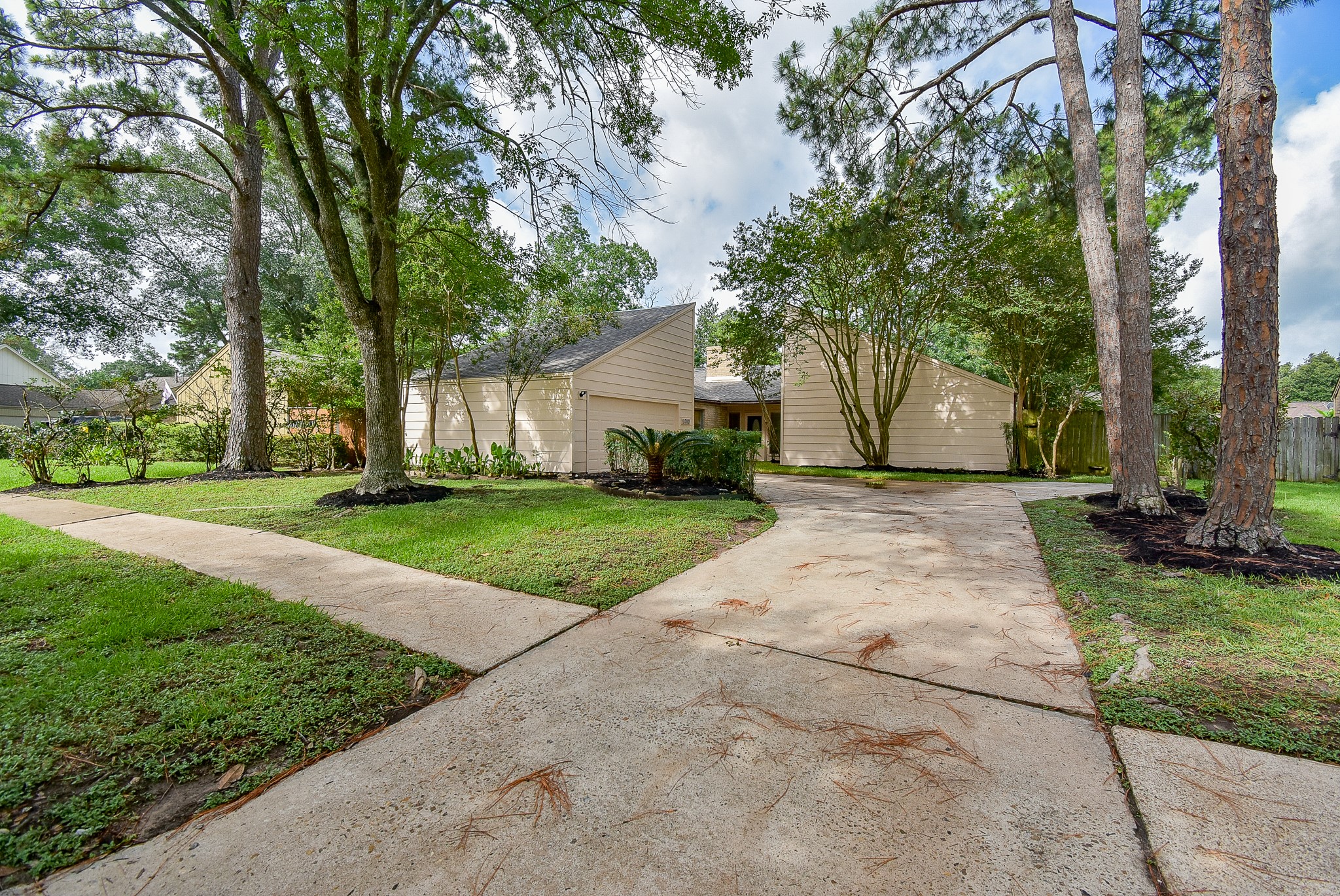 a view of a house with a yard and large tree