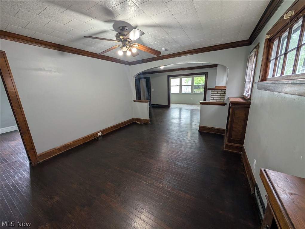 475 East 146th Street Cleveland, OH 44110 - Photo 9 of 28 Spacious room featuring dark wood-finish flooring, light gray walls, a textured white ceiling, and a ceiling fan with integrated lighting