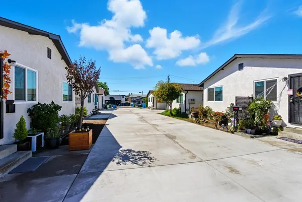 a view of a white house with a small yard and tv
