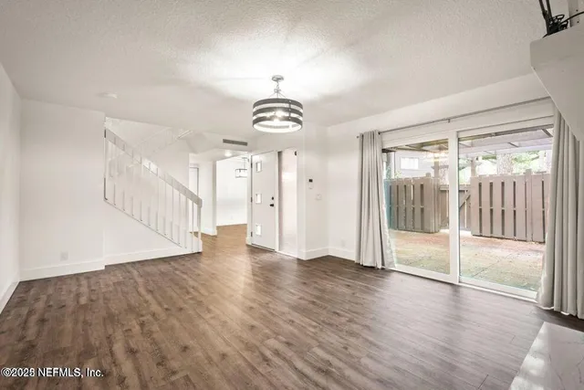 a view of a hallway with wooden floor and stairs