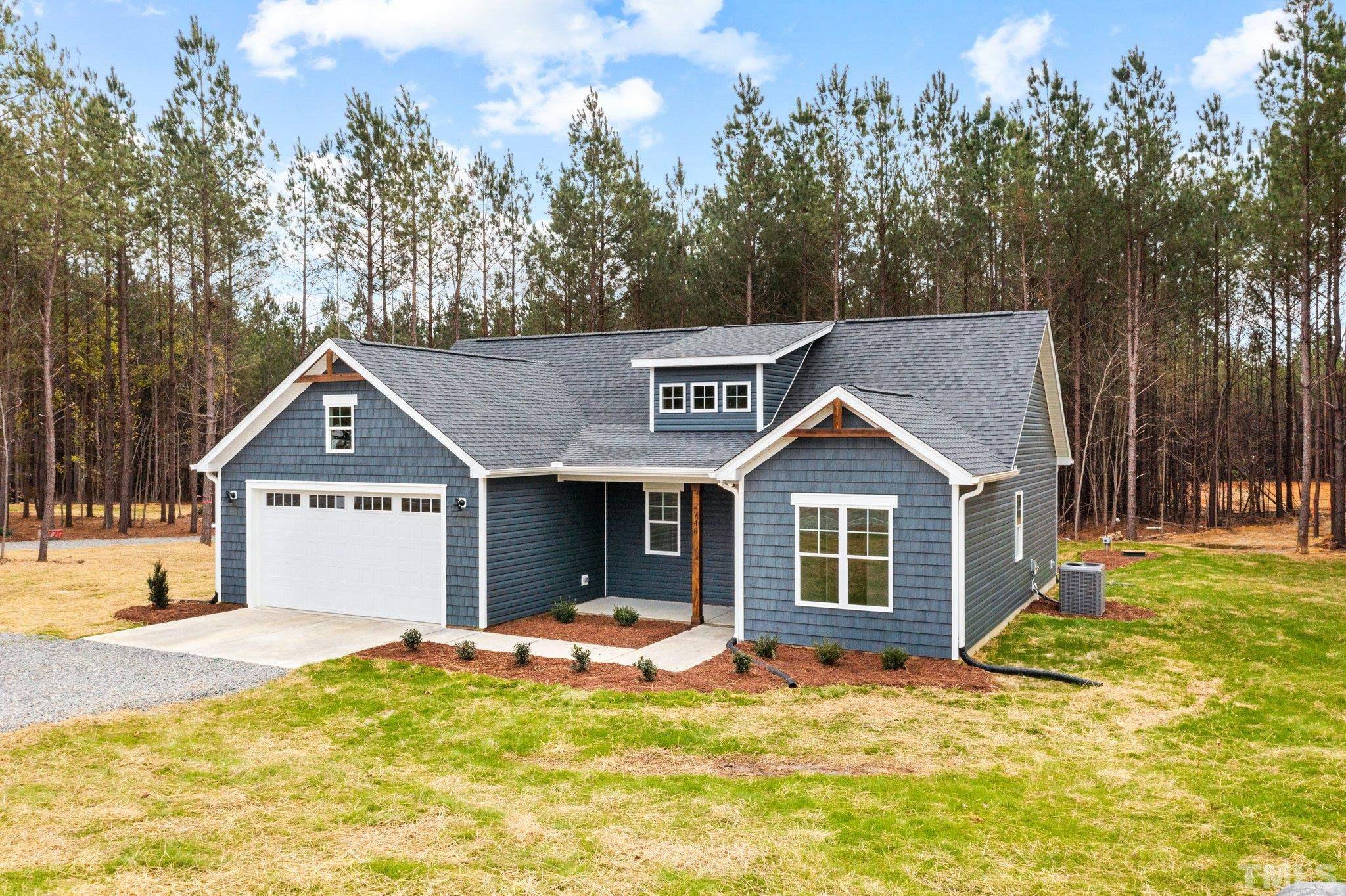 2748 Antioch Church Road Timberlake, NC 27583 - Photo 6 of 45 a front view of a house with a yard and garage
