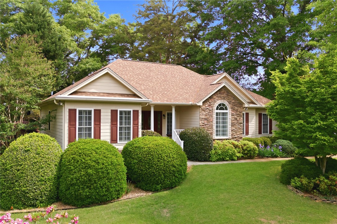 This charming residence features a well-maintained lawn and mature trees, creating a welcoming curb appeal.