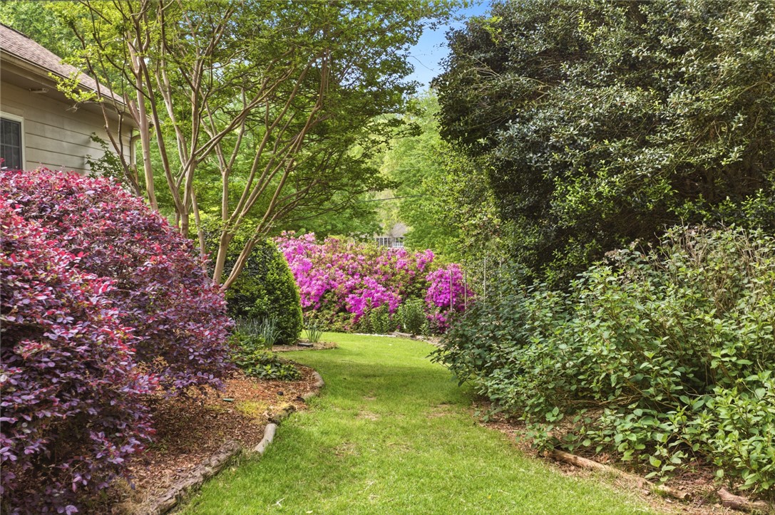 106 Cardinal Drive Seneca, SC 29672 - Photo 41 of 48 Lush landscaping and vibrant blossoms create a serene garden path.