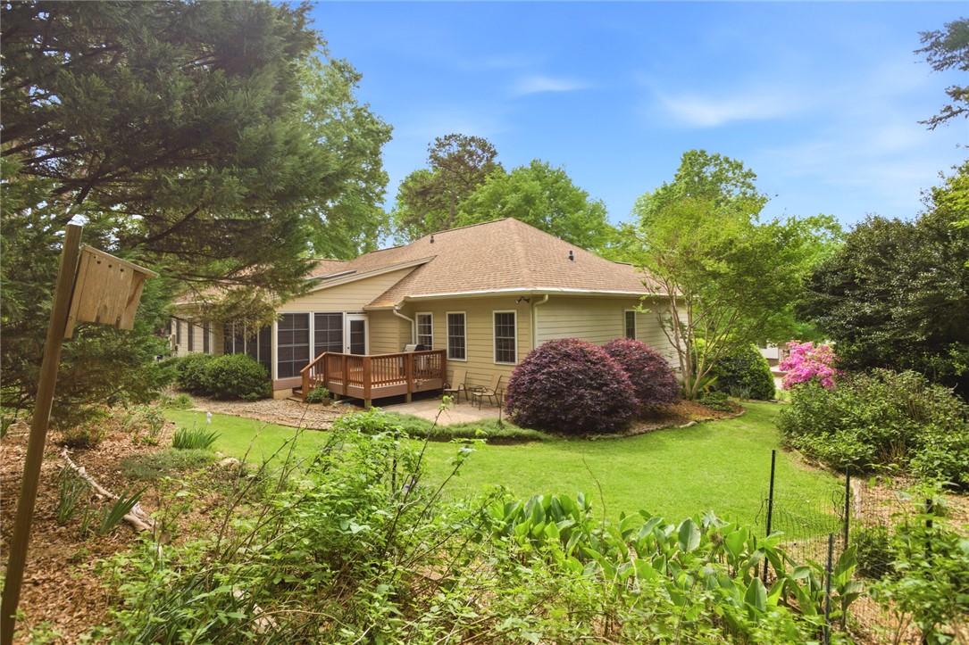 106 Cardinal Drive Seneca, SC 29672 - Photo 42 of 48 This residence showcases a large, lush backyard with mature trees, a deck, and screened porch.