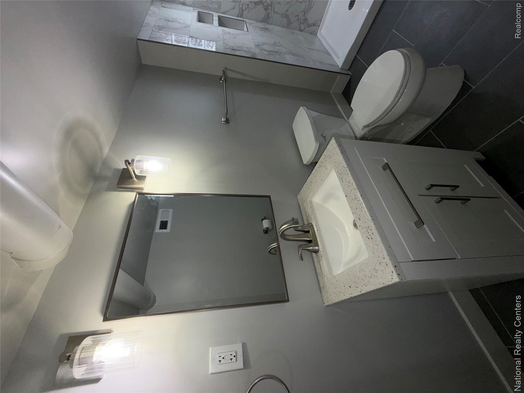 16522 Inverness Street Detroit, MI 48221 - Photo 45 of 62 Basement Bathroom featuring vanity, a stall shower, and dark tile patterned floors