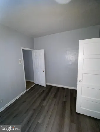 an empty room with wooden floor and cabinet