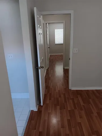 a view of a hallway with wooden floor and stairs