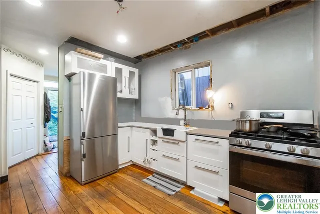 a kitchen with cabinets wooden floor and a dining table