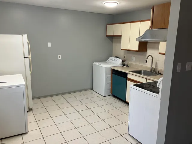 a kitchen with a sink a stove top oven and cabinets