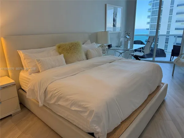 a large bed sitting in a bedroom next to a lamp