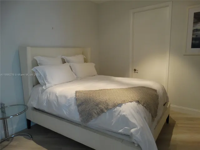 a large bed sitting in a bedroom next to a window