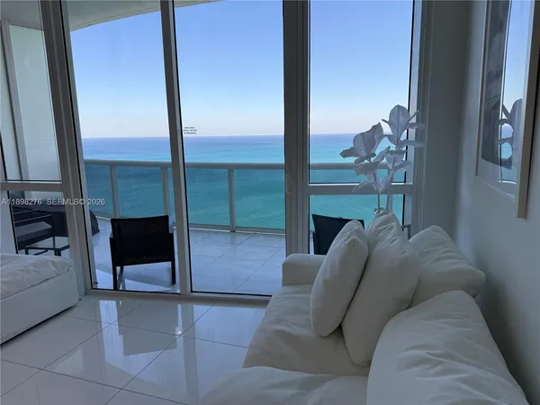 a living room with furniture and a floor to ceiling window