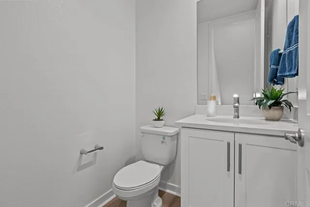 a bathroom with a granite countertop toilet sink and mirror