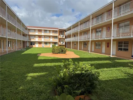 a front view of a building with a garden