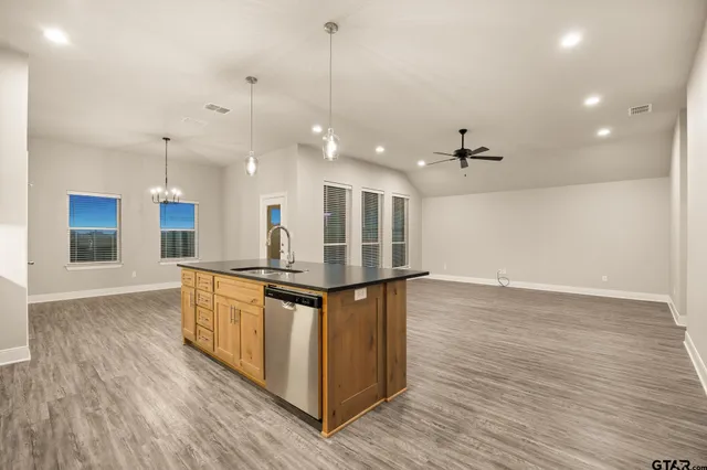 a kitchen with stainless steel appliances granite countertop a stove a sink and a wooden floors