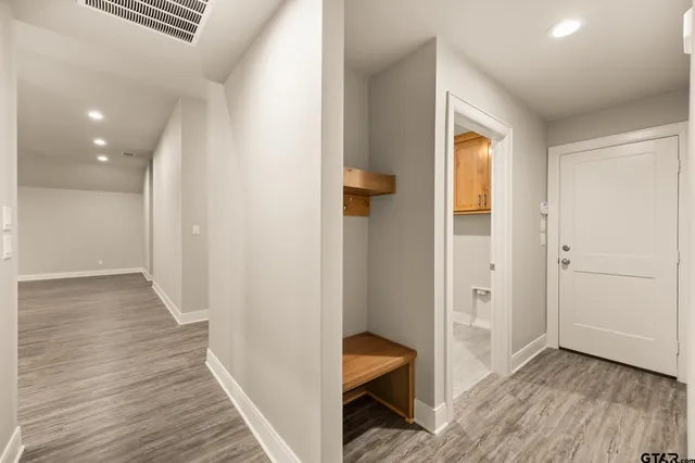a view of a hallway with wooden floor and closet
