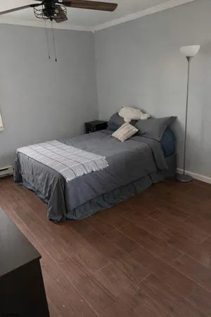 a bedroom with a bed and wooden floor