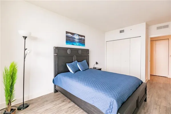 a bedroom with a bed and a potted plant
