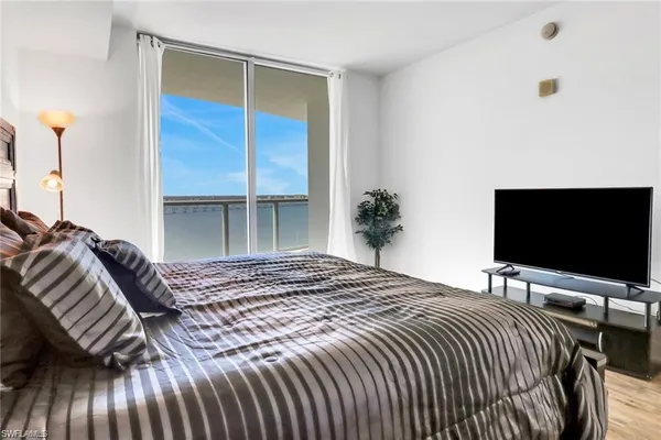 a bedroom with a bed and a flat screen tv