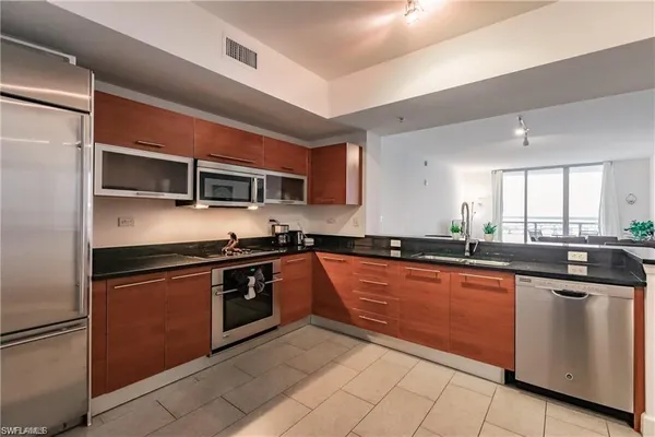 a kitchen with stainless steel appliances granite countertop a stove a sink and a microwave
